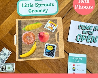 Puede incluir: Un juego de simulación de tienda de comestibles con una bandeja de madera, un letrero que dice "Little Sprouts Grocery" y una lista de compras con imágenes de una manzana y arándanos. La bandeja tiene un plátano, una dona, una manzana, una caja de arándanos y una caja de queso.