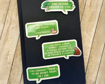 Puede incluir: Cuatro pegatinas de píxeles verdes y blancas con texto e imágenes. Las pegatinas están sobre una superficie negra. El texto en las pegatinas dice: "Oak Father Preserve You", "Ornaments, Utensils and Ducks. I Like Ducks", "You Aided a Bear Without Knowing If It Would Savage You. A True Friend of Nature. Or Perhaps a Lunatic", y "You Cannot Bear to Be Apart From Me I See."