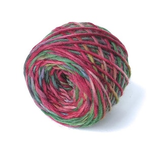 May include: A ball of colorful yarn with a mix of red, green, and purple hues. The yarn is tightly wound, creating a textured surface. Ideal for knitting, crocheting, or other fiber crafts.