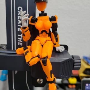 Puede incluir: Una taza de cerámica blanca con asa negra y el texto "But First, Coffee" en negrita negra. La taza se encuentra sobre un fondo borroso, sugiriendo un ambiente acogedor.