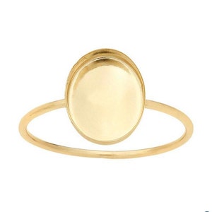 Puede incluir: Un anillo de oro con un bisel redondo y vac&iacute;o. El anillo est&aacute; hecho de metal y tiene un acabado liso.