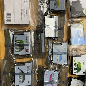 May include: Assortment of ink cartridges for printers in various colors, including black, cyan, magenta, and yellow. The cartridges are packaged in clear plastic bags and labeled with the brand names "FreeSUB", "JARBO", and "LDProducts.com".