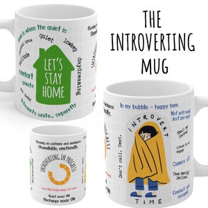 May include: White ceramic mugs with humorous text and graphics. One mug says "Let's Stay Home" in a green house shape. Another mug features a person wrapped in a yellow blanket. The text "The Introverting Mug" is also visible.