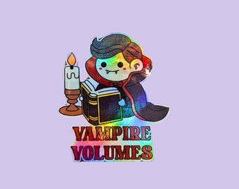 May include: A holographic sticker featuring a cartoon vampire reading a book next to a candle. The sticker has the text "VAMPIRE VOLUMES" and "WATERPROOF VINYL STICKER" in red and white. The background is a light purple.