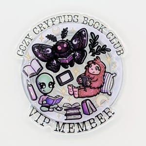 May include: A circular pin with the text "COZY CRYPTIDS BOOK CLUB VIP MEMBER". The pin features cartoon illustrations of a moth, alien, and Bigfoot reading books. The moth has black wings with white stars, and the alien is green.