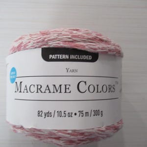 May include: A ball of Macrame Colors yarn in shades of pink and white. The label indicates that a pattern is included. The yarn is 82 yards and 10.5 ounces.