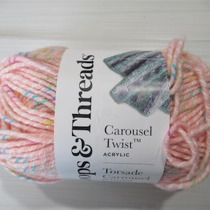 May include: A skein of pink acrylic yarn with a white label. The label reads "Loops & Threads Carousel Twist Acrylic". The yarn has flecks of blue, yellow, and green throughout. Ideal for knitting and crochet projects.