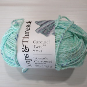 May include: A skein of Loops & Threads Carousel Twist acrylic yarn in a light teal color with flecks of white and blue. The label reads "Carousel Twist Acrylic" and "Torsade Carrousel". The yarn weighs 5.3 oz and is 213 yards long.