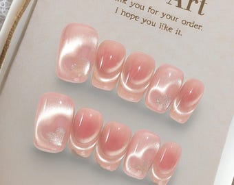 May include: Two sets of pink press-on nails with a pearlescent effect. The nails have a square shape and a glossy finish. The background includes a tag that reads "Nail Art" and "Thank you for your order. I hope you like it."