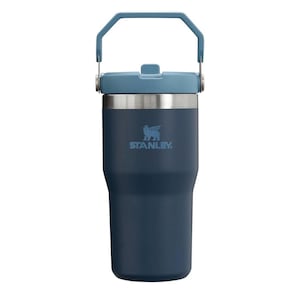 May include: A navy blue Stanley tumbler with a light blue handle and lid. The stainless steel band separates the navy blue body from the light blue lid. The Stanley logo is printed in light blue on the front of the tumbler.