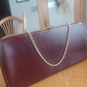 Granate vintage con cadena en tono dorado y cierre a presión.