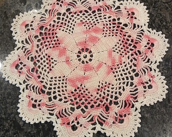 Doily, hand crocheted 11 1/2" diameter round variegated pink and ivory.
