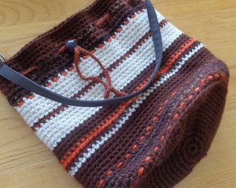 Handmade crocheted bucket bag. Orange, brown and white. Lined in African print cotton with divided pocket.
