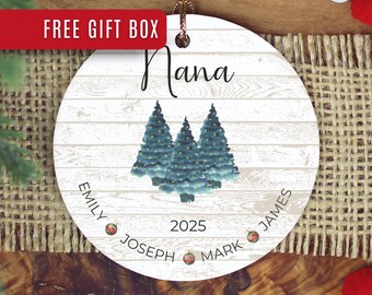 May include: A round Christmas ornament with a white wood-grain background. The word "Nana" is written in cursive above three blue Christmas trees. The names Emily, Joseph, James, and Mark are written around the bottom, with the year 2025. A red banner says "FREE GIFT BOX".