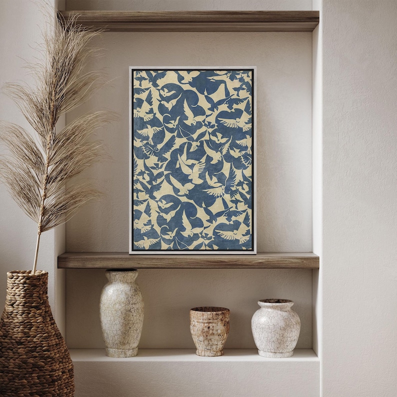 May include: A framed print with a blue and white pattern of birds flying in a flock. The print is displayed on a shelf with two white ceramic vases and a brown ceramic vase.