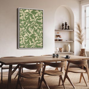 Puede incluir: Una obra de arte enmarcada con un patr&oacute;n repetido de p&aacute;jaros verdes sobre un fondo beige. La obra de arte se exhibe en una habitaci&oacute;n luminosa con una mesa de comedor y sillas de madera. La est&eacute;tica general es moderna e inspirada en la naturaleza.