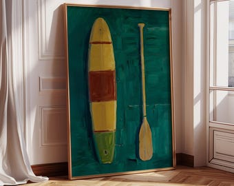 Op de afbeelding: Een abstract schilderij van een geel, bruin en groen surfboard en een peddel tegen een donkergroene achtergrond. Het kunstwerk is ingelijst in een goudkleurige lijst en leunt tegen een witte muur.