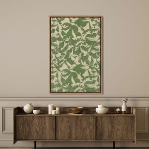 Puede incluir: Una obra de arte enmarcada con un patr&oacute;n repetido de palomas blancas sobre un fondo verde y beige. La obra de arte rectangular est&aacute; enmarcada en madera de color marr&oacute;n claro. El dise&ntilde;o tiene un ambiente vintage, ideal para la decoraci&oacute;n de interiores.