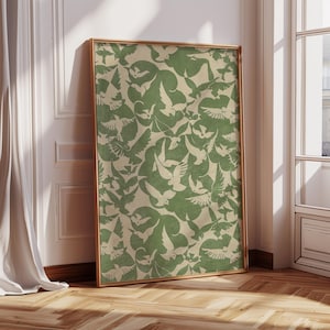 Puede incluir: Una impresi&oacute;n art&iacute;stica enmarcada con un patr&oacute;n repetido de palomas blancas sobre un fondo verde salvia y beige. La obra de arte est&aacute; en un marco dorado, apoyada contra una pared blanca y un suelo de madera.