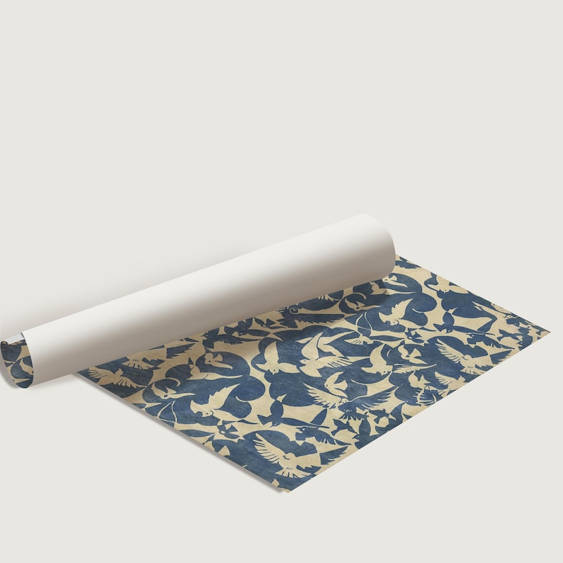 May include: A roll of wrapping paper with a blue and white pattern of birds. The paper is rolled up and partially unrolled, revealing the pattern.