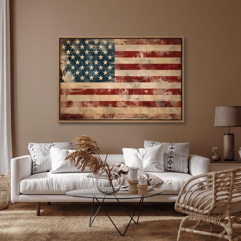 May include: A framed wooden American flag with a distressed, vintage appearance. The flag features red and white stripes and a blue field with white stars. The artwork is displayed in a living room setting.