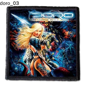 Puede incluir: Un parche blanco y negro con una imagen colorida de una mujer guerrera sosteniendo una espada. El texto "Doro Warrior Soul" está impreso en el parche.