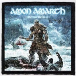 Puede incluir: Un parche en blanco y negro con el nombre de la banda "Amon Amarth" y el título del álbum "Jomsviking" en texto blanco. La imagen muestra a un guerrero vikingo con un hacha de pie en un mar tormentoso con un lobo y un cuervo en el fondo.
