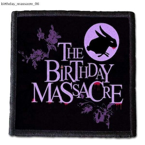 Op de afbeelding: Zwarte en paarse geborduurde patch met de tekst "The Birthday Massacre" in een druppelend bloedlettertype. Een zwart silhouet van een konijn met een enkele rode bloeddruppel op zijn neus bevindt zich in een paarse cirkel boven de tekst.