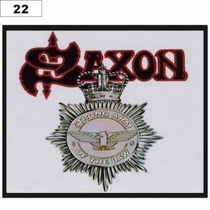 Peut inclure: Une pochette d'album blanche avec le nom du groupe "SAXON" en lettres noires et rouges. Le logo du groupe est un "S" stylisé avec une couronne au-dessus. Sous le logo se trouve un badge argenté avec les mots "STRONG ARM OF THE LAW" et un aigle ailé.