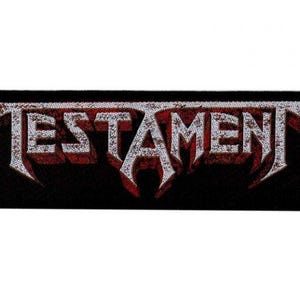 Puede incluir: Un parche negro con el nombre de la banda "TESTAMENT" en letras blancas con un contorno rojo. Las letras están estilizadas y tienen un aspecto desgastado.