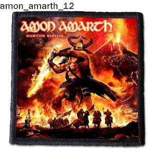 Puede incluir: Un parche negro y blanco con un fondo de fuego. El parche presenta una figura grande y musculosa empuñando una espada, con el texto "Amon Amarth" y "Surtur Rising" sobre la figura.