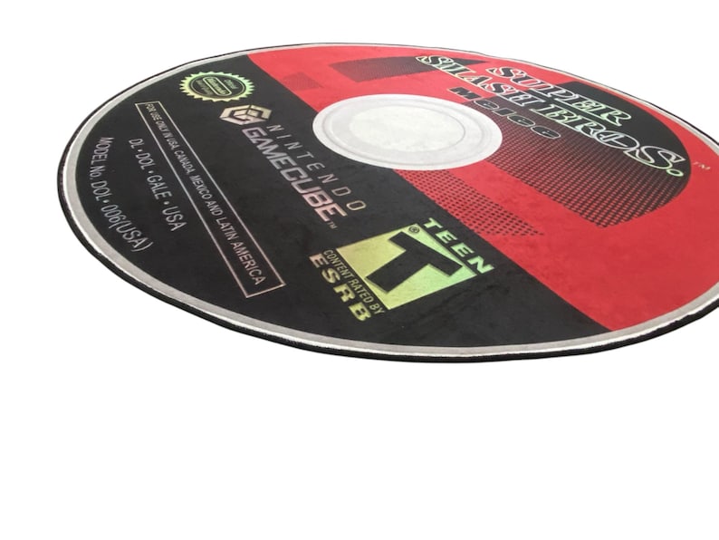 May include: A black and red GameCube game disc with the title "Super Smash Bros. Melee" printed on it. The disc is rated "T" for Teen by the ESRB.