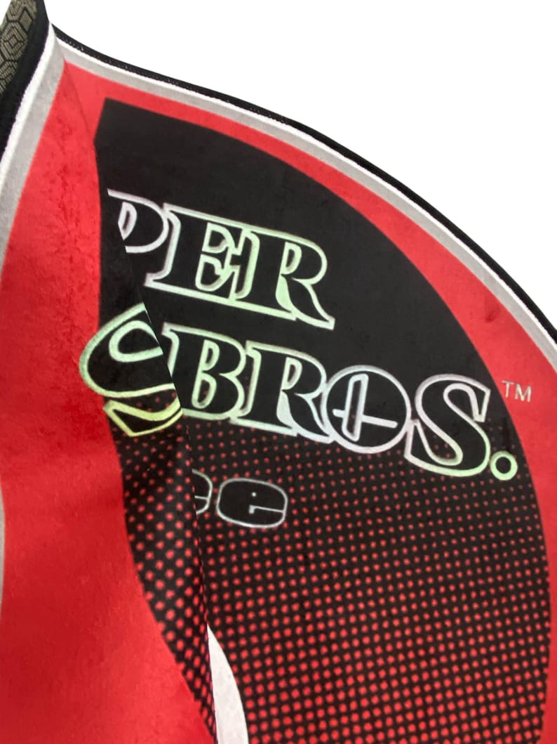 May include: A red and black Super Bros. rug with a white border. The rug has a black and white polka dot pattern.