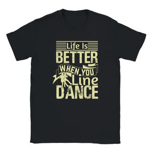 May include: Black t-shirt with a white graphic that says "Life is Better When You Line Dance". The graphic features a stylized couple line dancing.