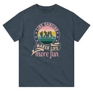 Op de afbeelding: Een donkerblauw t-shirt met een retro-stijl grafische afbeelding van mensen die linedance dansen. De afbeelding is omgeven door een cirkel met de tekst "Line Dancing Makes Life More Fun".