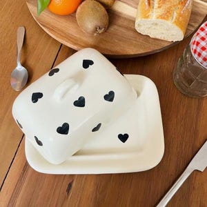 Beurrier décorée de cœurs en céramique, format rectangulaire, rangement élégant pour cuisine, fait main, accessoire artisanal pratique.