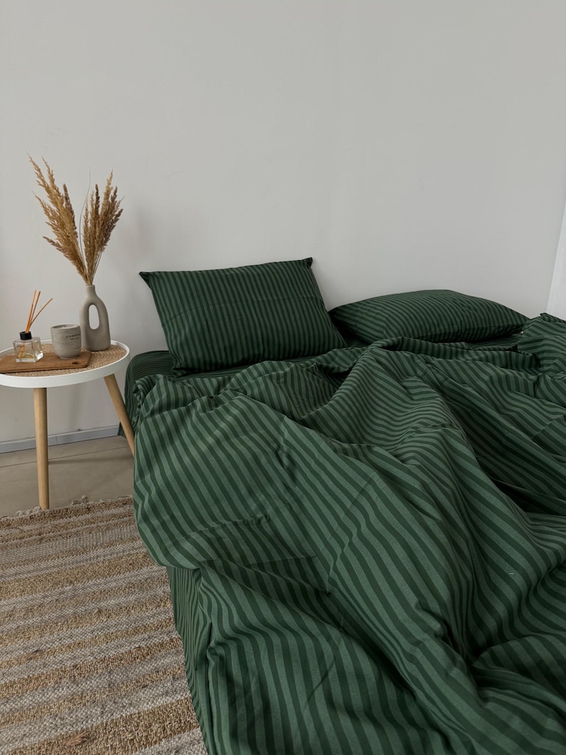 Puede incluir: Bedding de rayas verdes sobre fondo blanco. La ropa de cama est&aacute; hecha de tela suave y c&oacute;moda, perfecta para un dormitorio.
