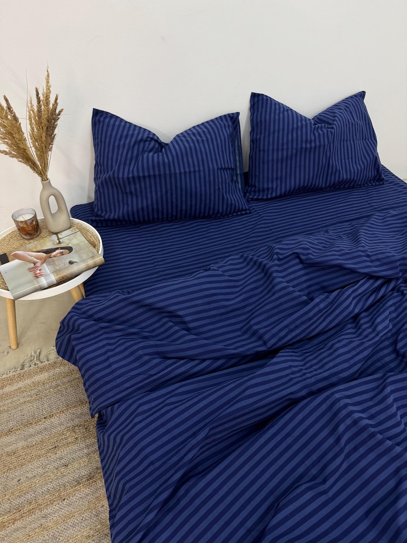 May include: A blue striped bedding set with a duvet cover and two pillowcases. The bedding is made of soft, comfortable fabric and features a classic striped pattern.