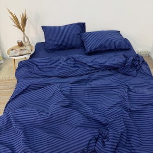 May include: A blue striped bedding set with a flat sheet, fitted sheet, and two pillowcases. The bedding is made of soft, comfortable fabric and is perfect for any bedroom.