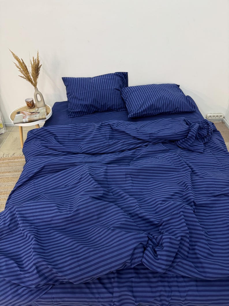 May include: A blue striped bedding set with a flat sheet, fitted sheet, and two pillowcases. The bedding is made of soft, comfortable fabric and is perfect for any bedroom.