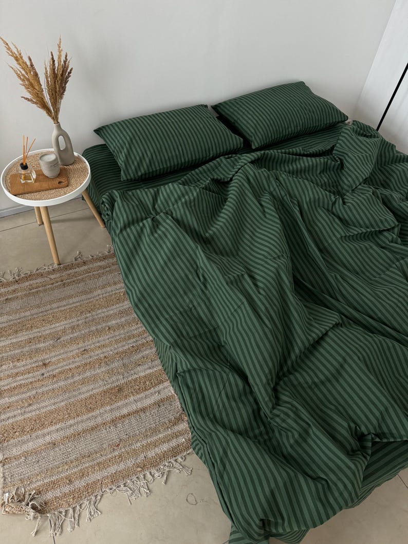 Puede incluir: Bedding de rayas verdes con una alfombra de rayas blancas y beige. La ropa de cama est&aacute; hecha de una tela suave y c&oacute;moda y es perfecta para un dormitorio.