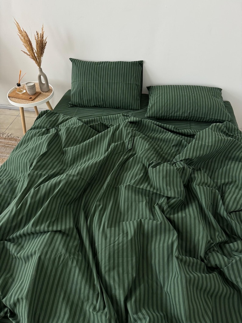 Puede incluir: Un juego de s&aacute;banas de cama a rayas verdes con dos fundas de almohada a juego. La s&aacute;bana est&aacute; hecha de una tela suave y c&oacute;moda y tiene un brillo sutil.