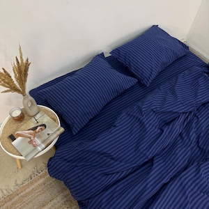 May include: A blue striped bedding set with a duvet cover and two pillowcases. The bedding is made of soft, comfortable fabric and features a classic striped pattern.