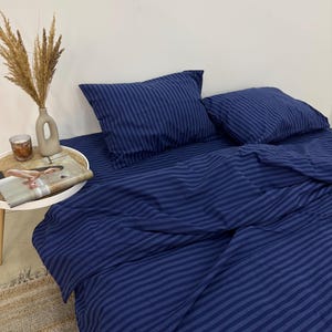 May include: A blue striped bedding set with two matching pillowcases. The bedding is made of a soft, comfortable fabric and features a classic striped pattern.