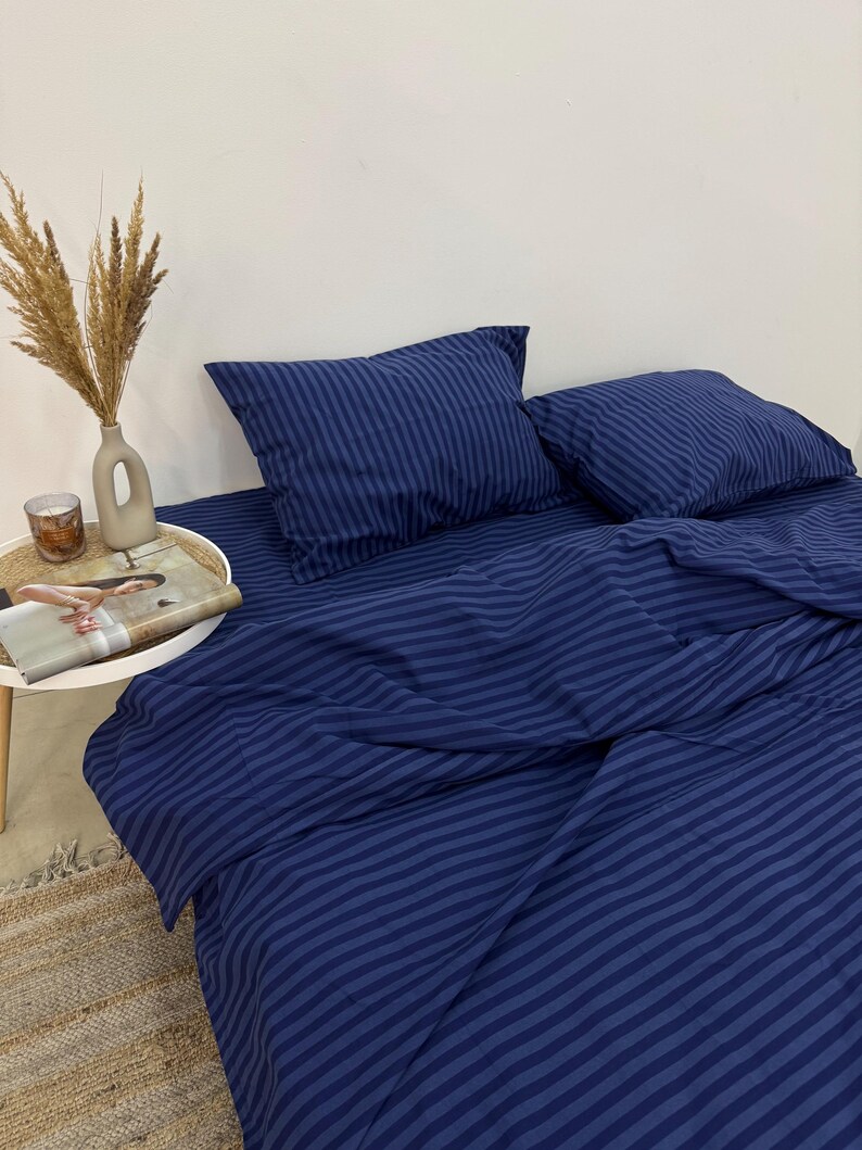May include: A blue striped bedding set with two matching pillowcases. The bedding is made of a soft, comfortable fabric and features a classic striped pattern.