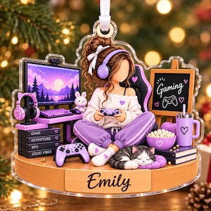 May include: A decorative acrylic ornament featuring a girl with brown hair wearing purple headphones, sitting in a gaming chair. She holds a controller near a computer monitor, a chalkboard labeled Gaming, a bowl of popcorn, and a sleeping cat.