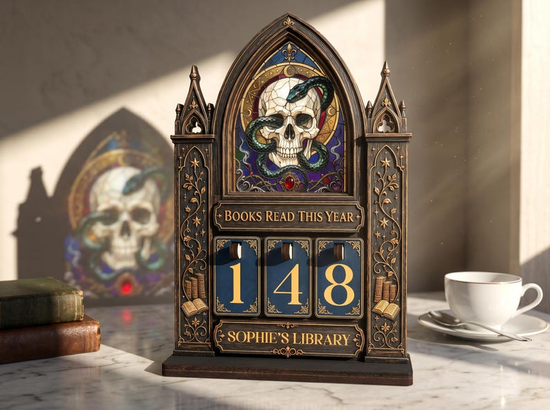 May include: A dark-toned, gothic-style wooden book tracker featuring an arched top with a stained-glass style skull and snake design. It includes a plaque reading BOOKS READ THIS YEAR, three rotating number dials displaying 148, and a base plaque reading SOPHIE'S LIBRARY.