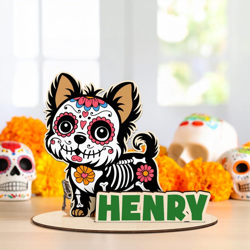May include: A wooden Day of the Dead-themed dog decoration. The dog is black and white with a sugar skull design on its face and skeleton details on its body. The name "HENRY" is displayed in green letters on a wooden base.