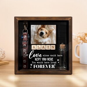 May include: A wooden shadow box with a photo of a dog, a dog collar, and a small glass bottle. The photo is above the text "If love alone could have kept you here, you would have lived forever."