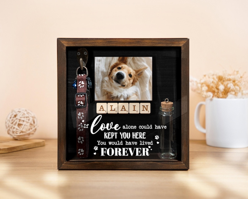 May include: A wooden shadow box with a photo of a dog, a dog collar, and a small glass bottle. The photo is above the text "If love alone could have kept you here, you would have lived forever."